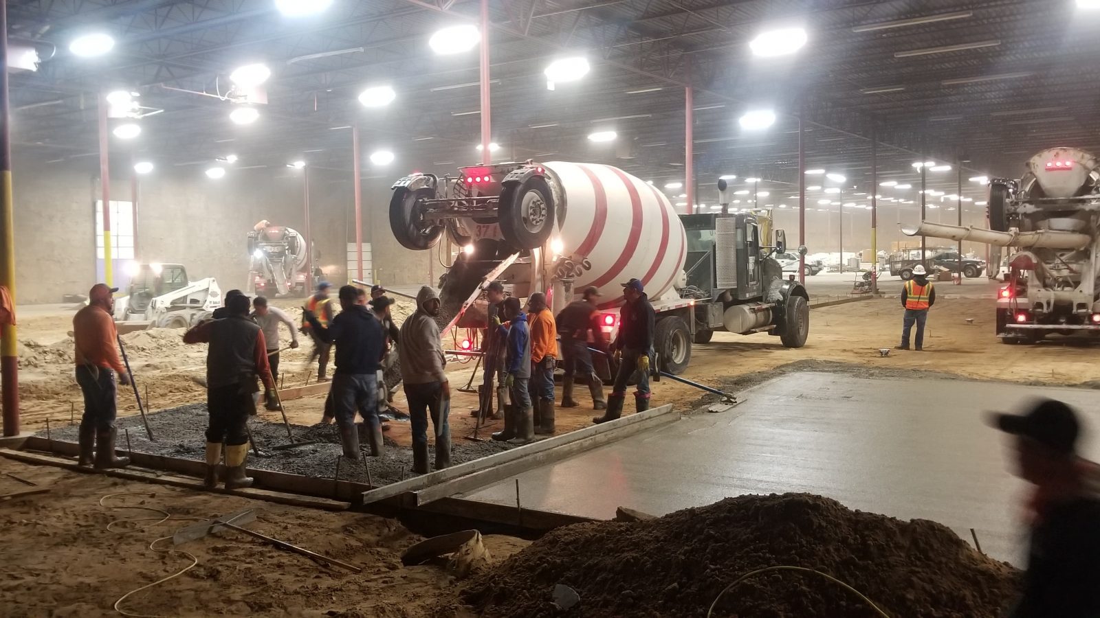 Crew placing a warehouse concrete slab at night